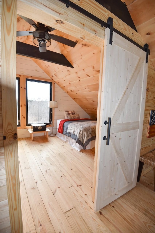 unfurnished bedroom with wooden walls, wooden ceiling, light hardwood / wood-style flooring, and lofted ceiling