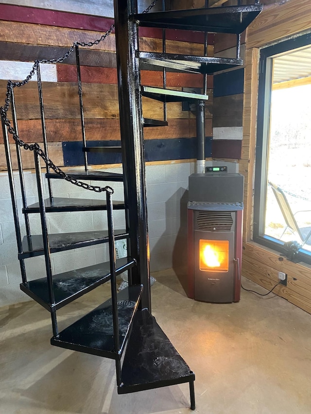 basement featuring a wood stove and wood walls