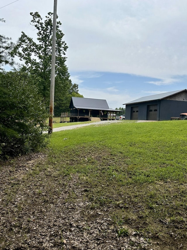 view of yard with a garage and an outbuilding