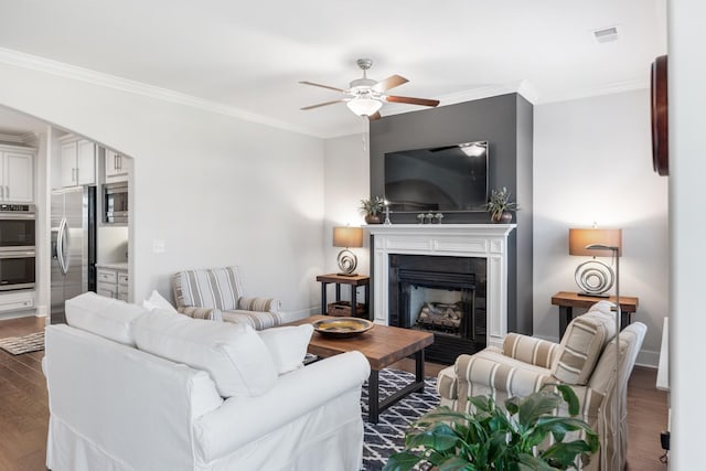 living room featuring hardwood / wood-style flooring, ceiling fan, and crown molding