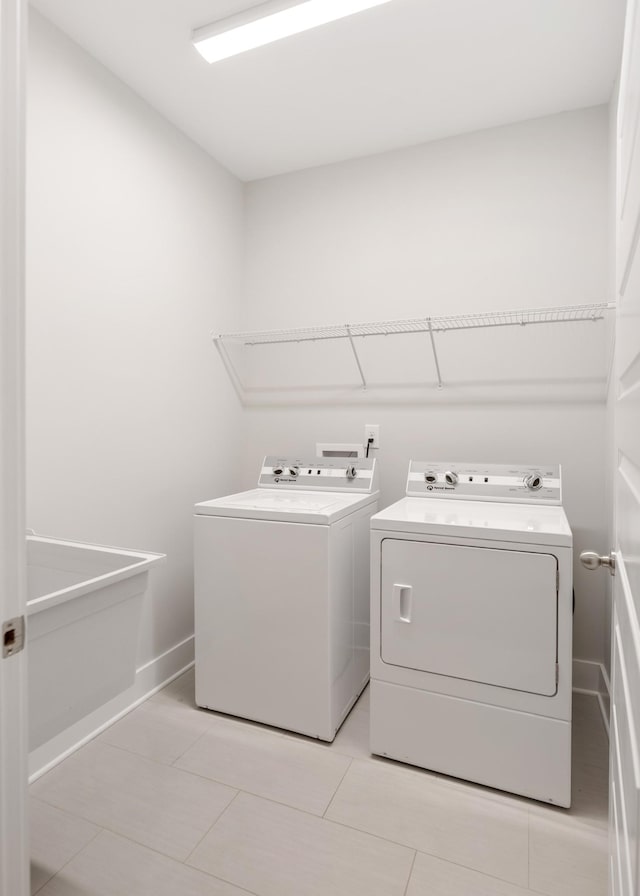 laundry room with separate washer and dryer and light tile patterned floors