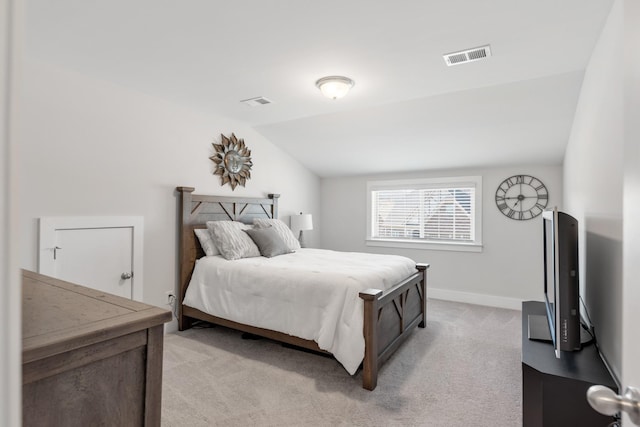 bedroom featuring lofted ceiling and light carpet