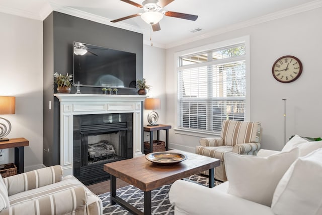 living room with wood-type flooring, ceiling fan, and ornamental molding