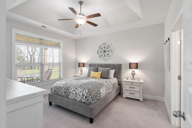 bedroom featuring a tray ceiling, ceiling fan, and light colored carpet