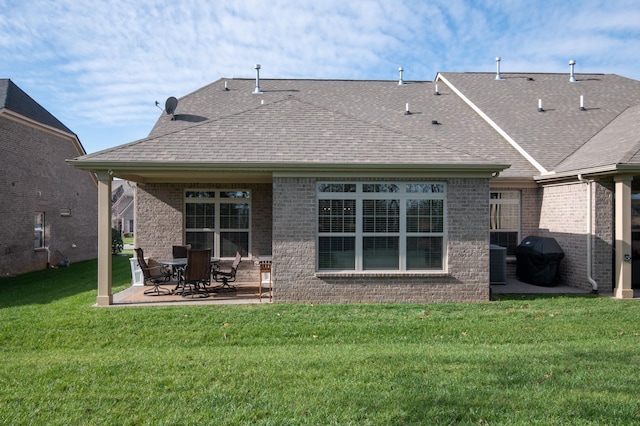 rear view of property featuring a lawn, a patio, and central AC