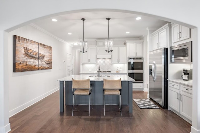 kitchen featuring white cabinetry, hanging light fixtures, stainless steel appliances, tasteful backsplash, and crown molding