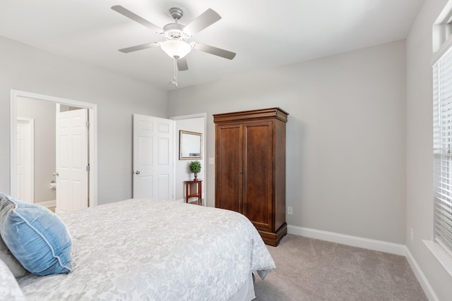 carpeted bedroom featuring ceiling fan and ensuite bath