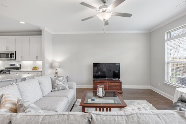 living room with dark hardwood / wood-style floors, a healthy amount of sunlight, crown molding, and ceiling fan