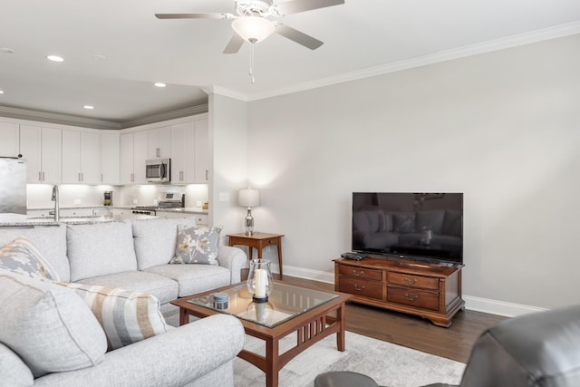 living room with ceiling fan, wood-type flooring, ornamental molding, and sink