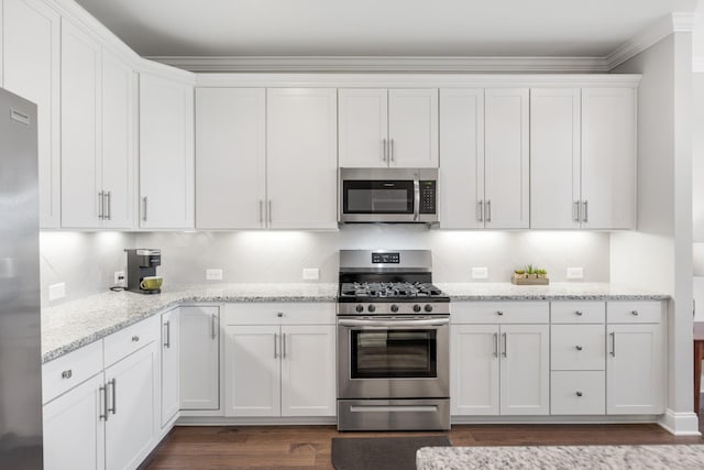 kitchen featuring white cabinets, appliances with stainless steel finishes, and light stone countertops