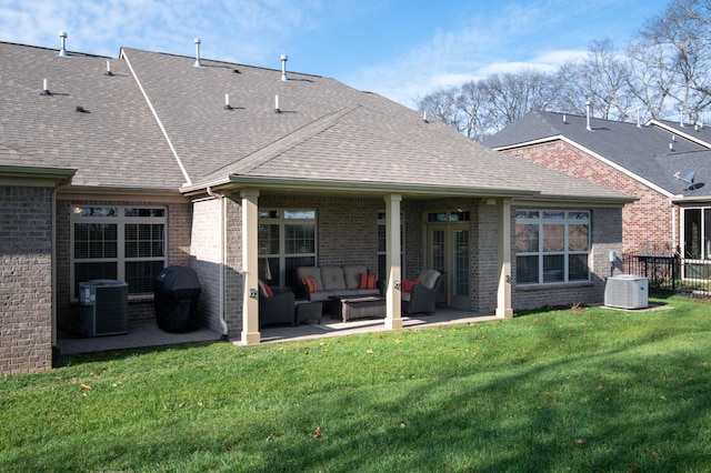 back of house with an outdoor living space, a lawn, and central air condition unit