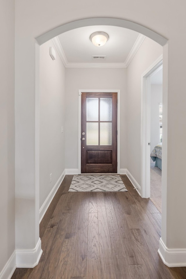 foyer entrance with dark hardwood / wood-style flooring and ornamental molding