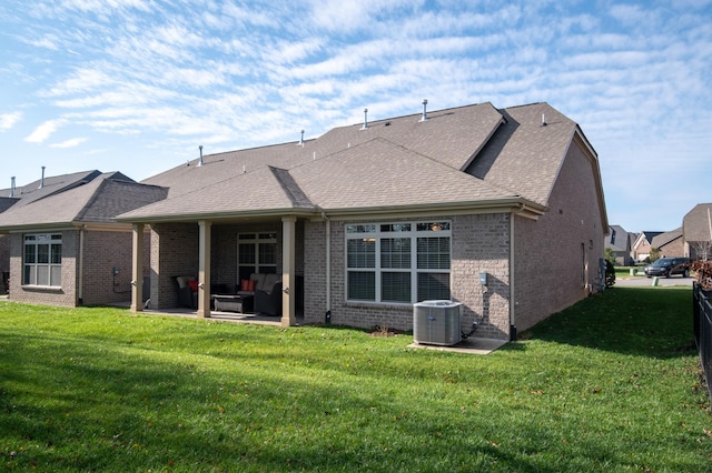 rear view of property featuring a lawn, cooling unit, and a patio