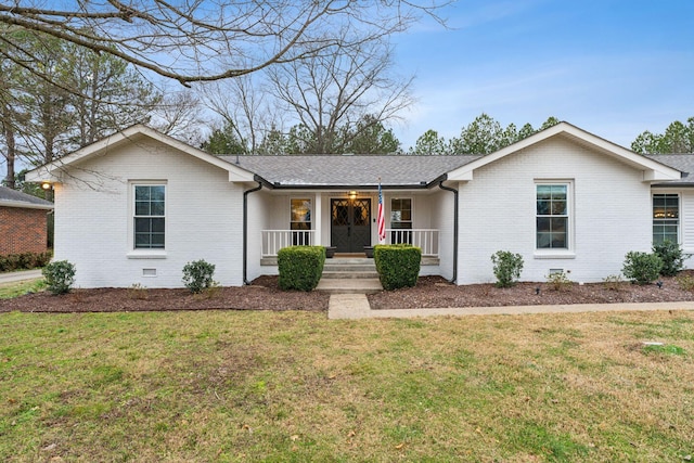 ranch-style house featuring covered porch and a front yard