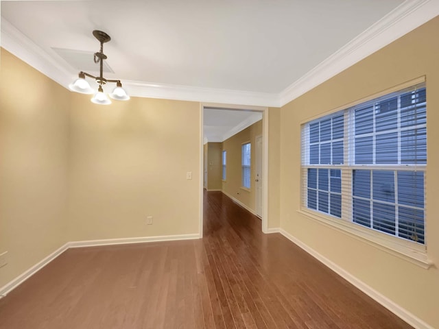 empty room with dark hardwood / wood-style floors, an inviting chandelier, and crown molding