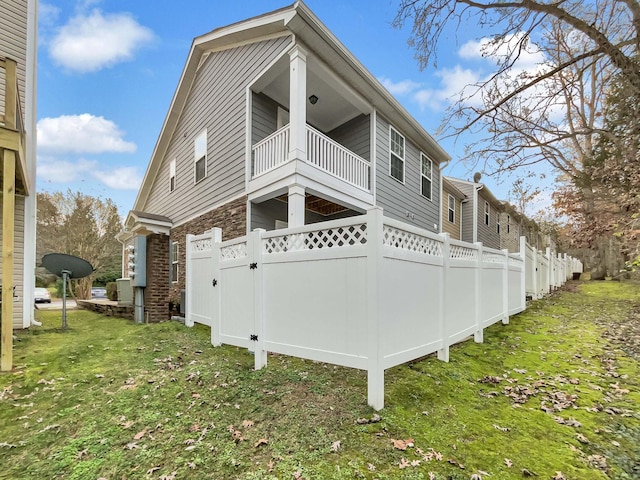 view of property exterior featuring a yard and a balcony