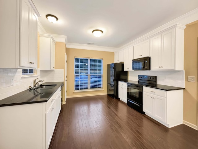 kitchen featuring decorative backsplash, white cabinetry, sink, and black appliances