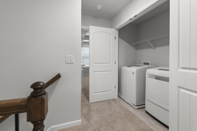 clothes washing area with light carpet and washer and clothes dryer