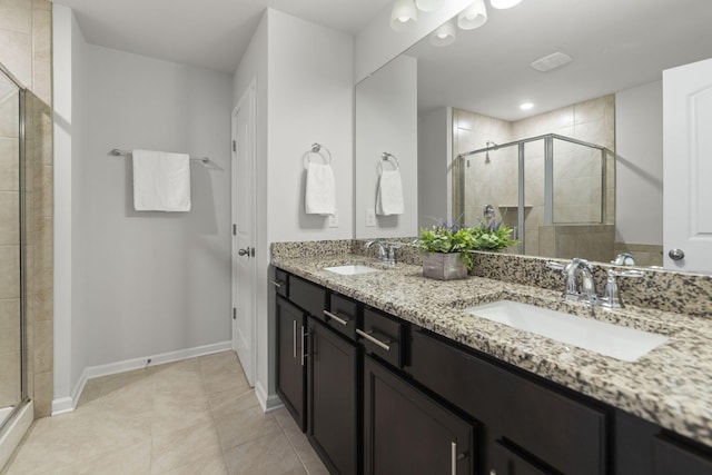 bathroom with tile patterned flooring, vanity, and a shower with door