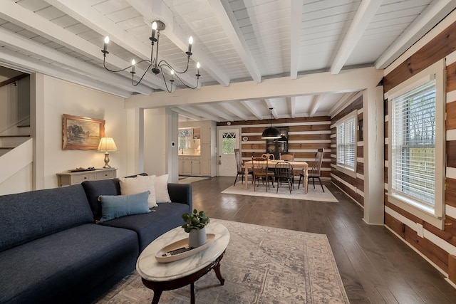 living room with beam ceiling, dark hardwood / wood-style floors, and a notable chandelier