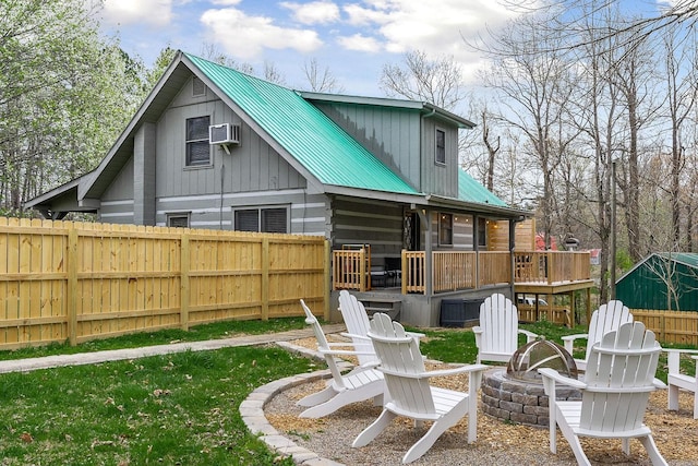 back of property featuring a fire pit and a deck