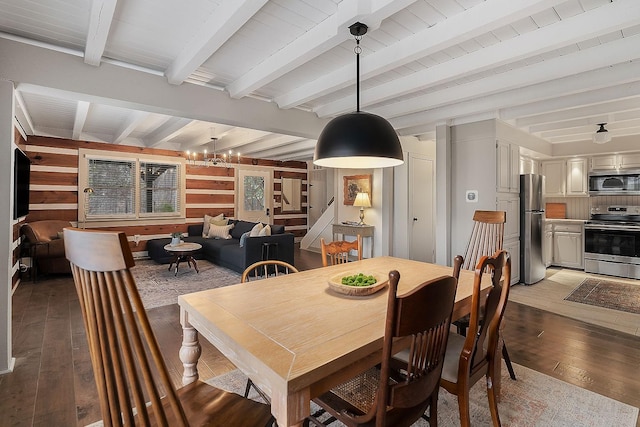 dining space featuring beam ceiling, wood walls, light hardwood / wood-style flooring, and a chandelier