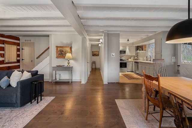 dining space featuring beamed ceiling, dark hardwood / wood-style flooring, wood ceiling, and sink