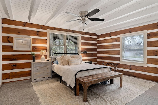 bedroom with beam ceiling, ceiling fan, wooden walls, and light colored carpet