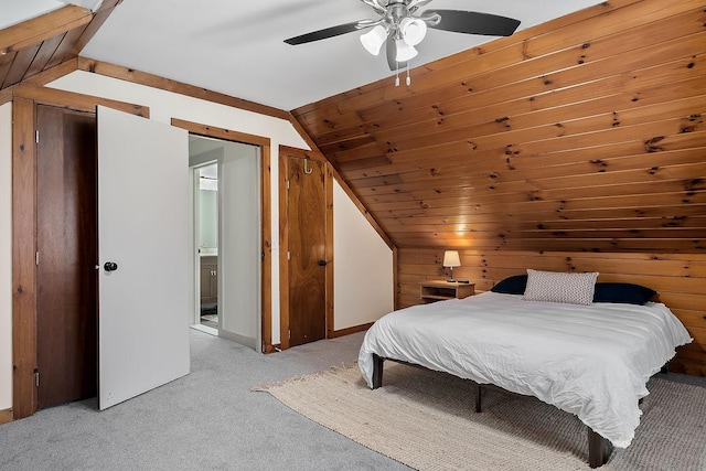 bedroom with ceiling fan, ensuite bathroom, light carpet, and vaulted ceiling