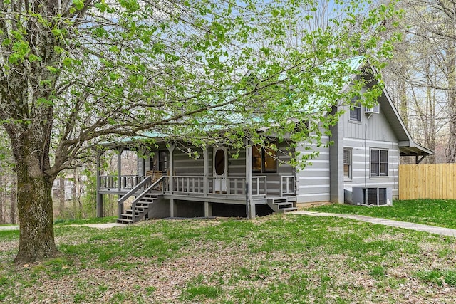 back of house featuring a lawn and cooling unit