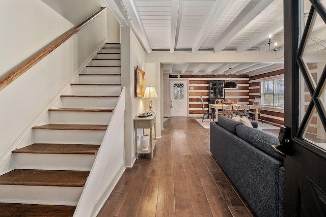 stairway with beamed ceiling and wood-type flooring