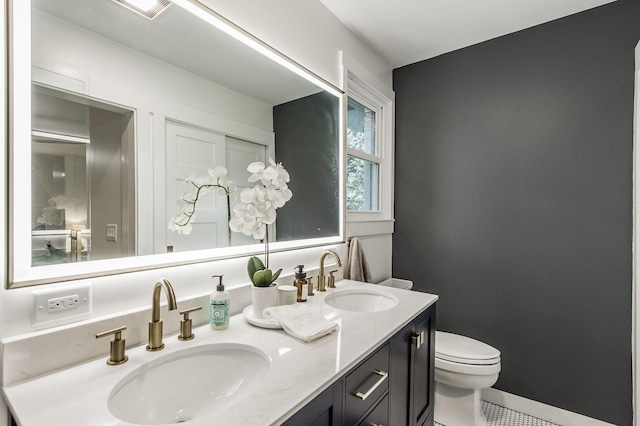 bathroom with tile patterned flooring, vanity, and toilet