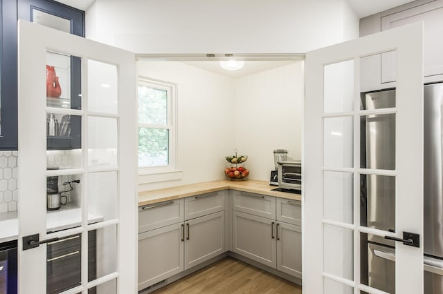 kitchen featuring butcher block countertops, gray cabinets, and light hardwood / wood-style flooring