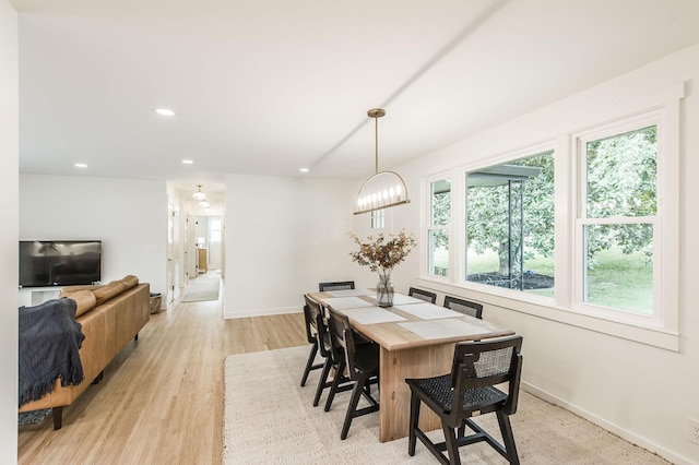 dining room with light hardwood / wood-style flooring and a chandelier