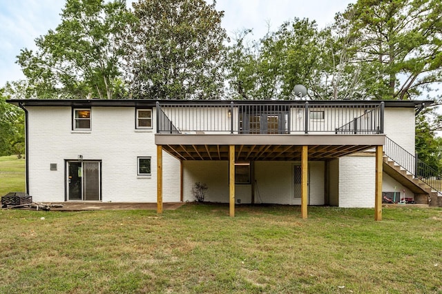 rear view of house with a lawn and a wooden deck