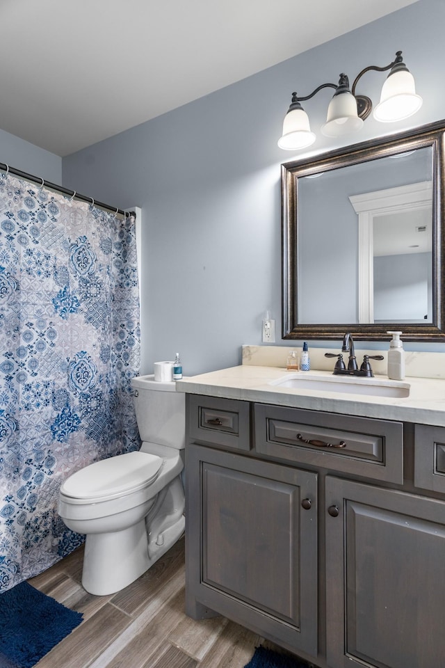 bathroom featuring toilet, vanity, and hardwood / wood-style flooring