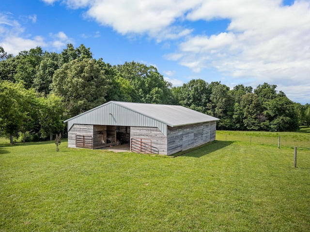 view of outbuilding featuring a lawn and a rural view