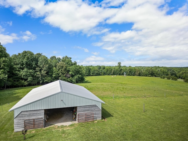 view of outbuilding featuring a lawn and a rural view