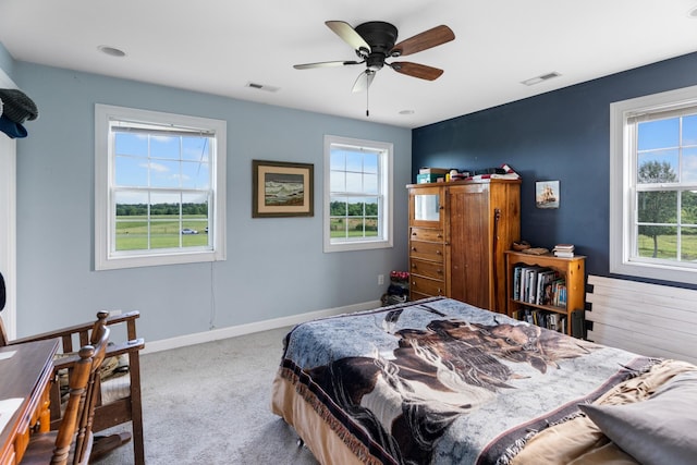 carpeted bedroom featuring ceiling fan and multiple windows