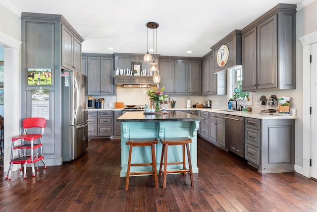 kitchen featuring a center island, sink, stainless steel appliances, dark hardwood / wood-style flooring, and pendant lighting