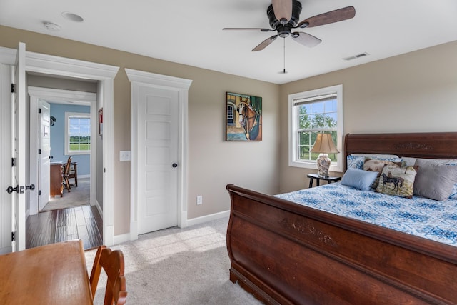 carpeted bedroom with multiple windows and ceiling fan