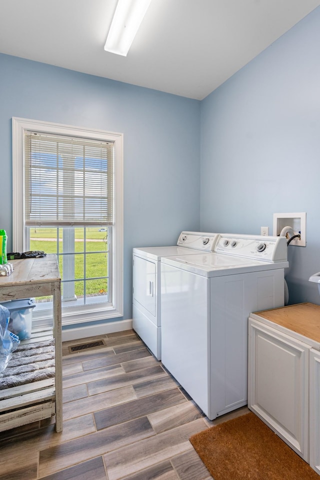 laundry area featuring separate washer and dryer and light hardwood / wood-style floors