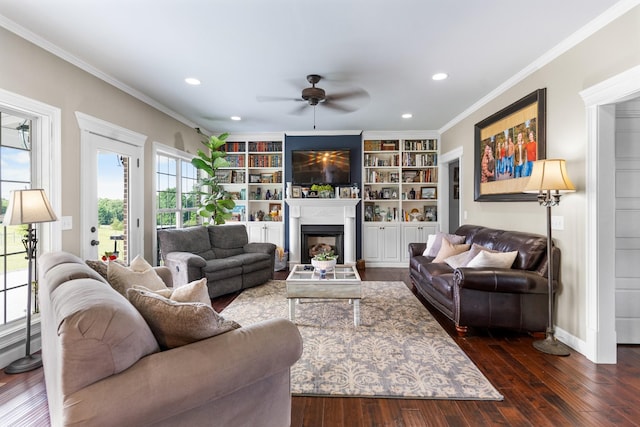 living room with dark hardwood / wood-style floors, ceiling fan, built in features, and ornamental molding