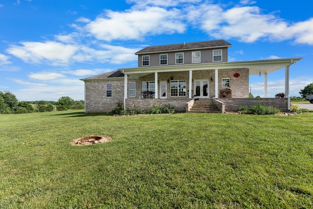 view of front of house with an outdoor fire pit, a front yard, and french doors