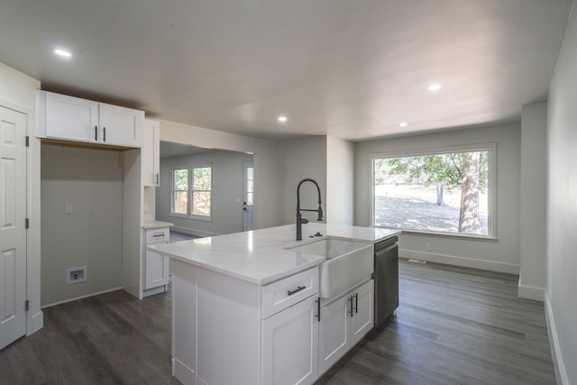 kitchen with a kitchen island with sink, white cabinets, sink, dark hardwood / wood-style floors, and light stone counters