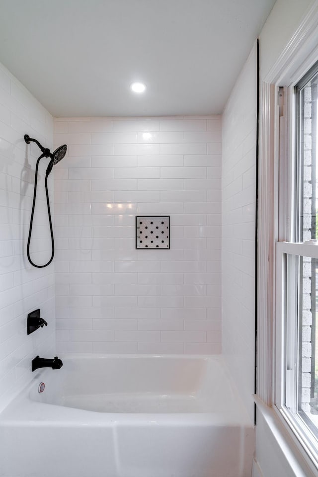 bathroom featuring plenty of natural light and tiled shower / bath combo