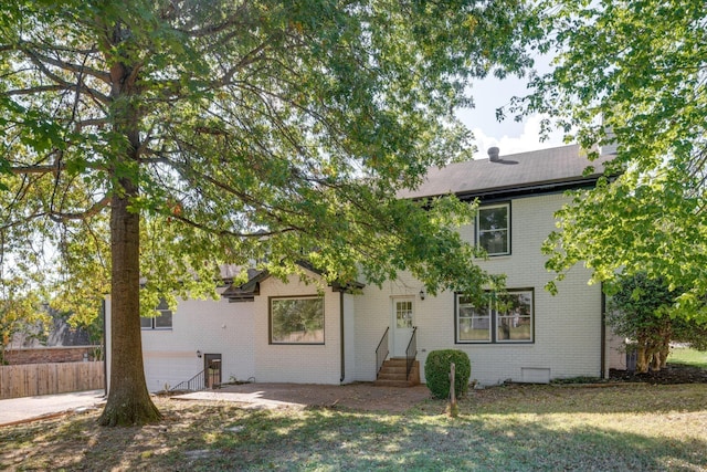 rear view of house featuring a yard and a garage