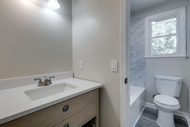 bathroom featuring vanity, hardwood / wood-style flooring, toilet, and a bathing tub