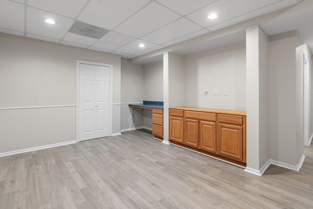 bar with a paneled ceiling and light hardwood / wood-style flooring