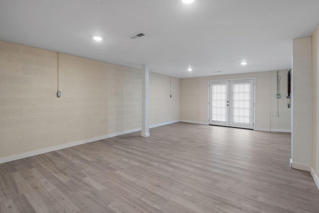 empty room featuring french doors and light wood-type flooring